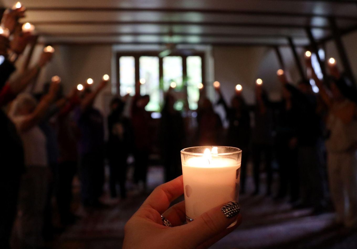 A person holding a candle in front of a group.
